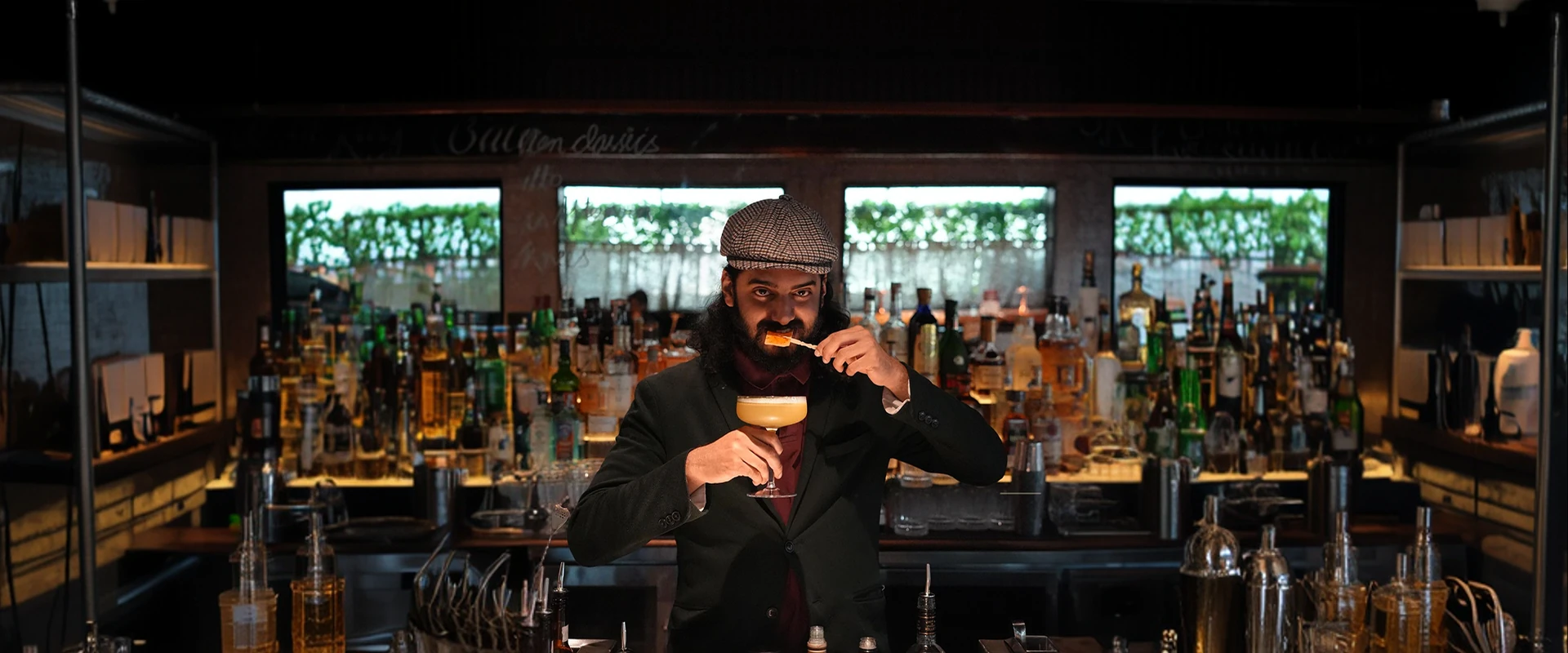 Mayur Marne behind the bar holding a coupe cocktail
