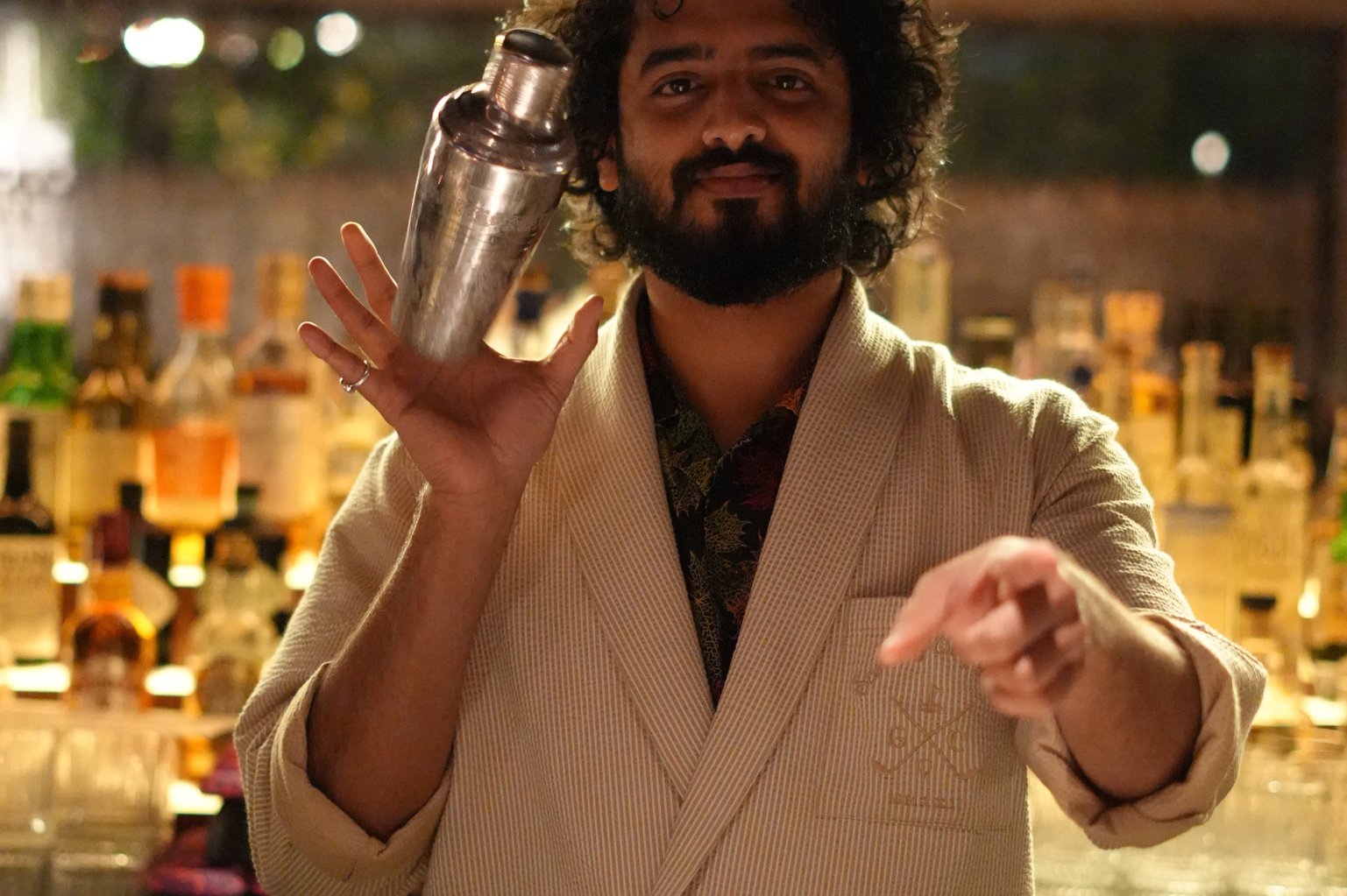 Mayur tossing a cocktail shaker behind the bar