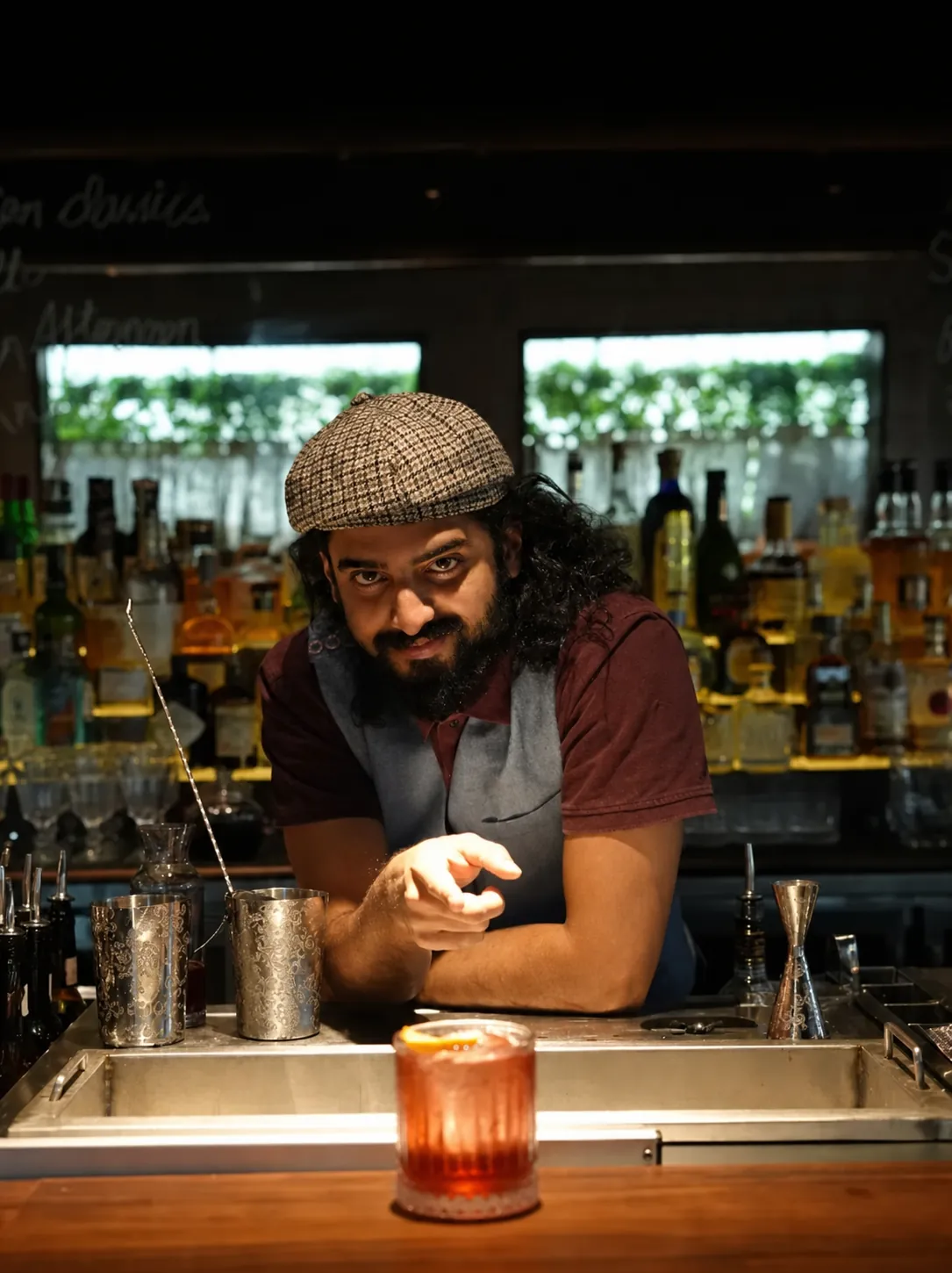 Mayur presenting a cocktail behind the bar
